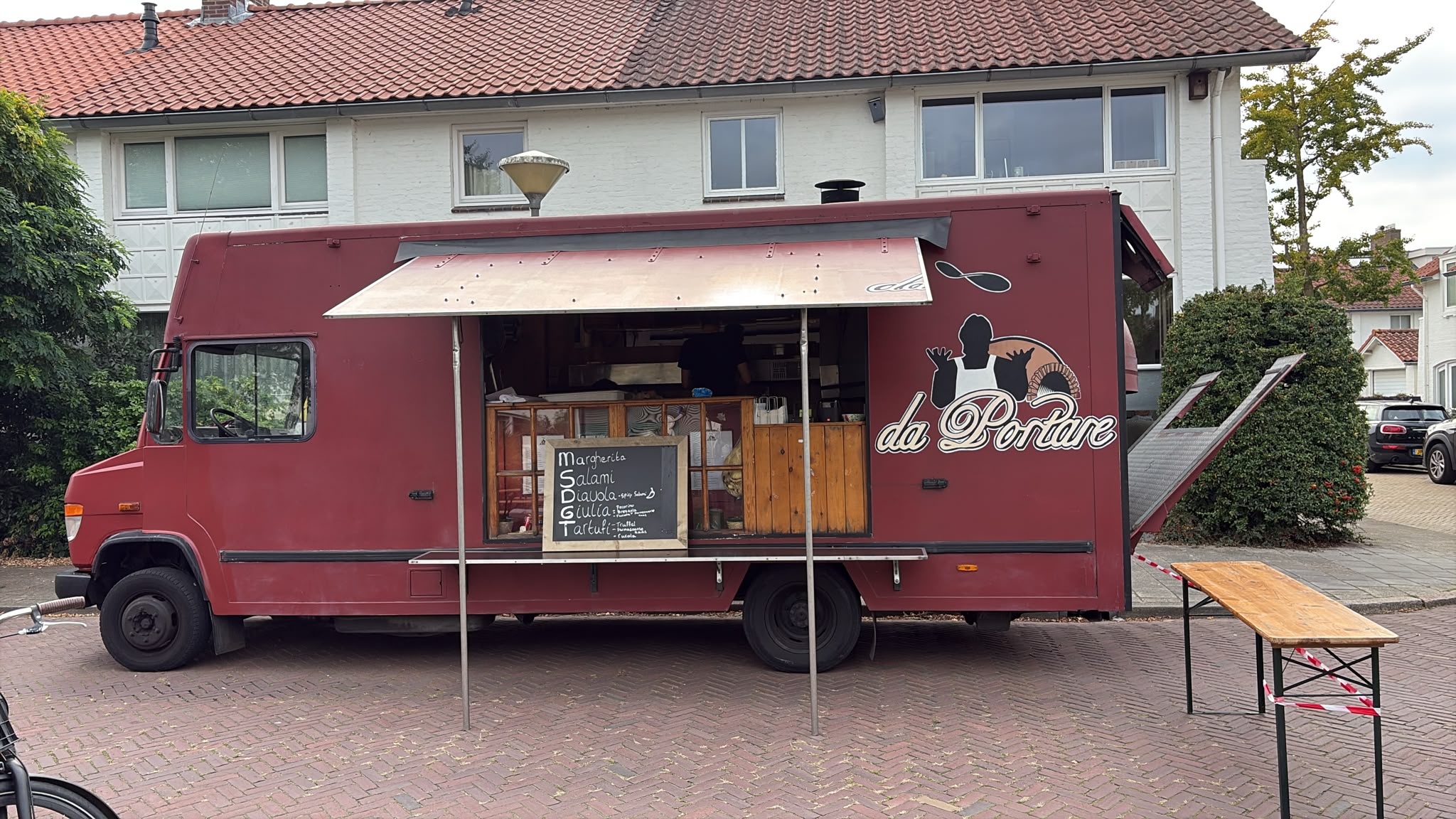 Pizza truck in the street in front of the white houses of Sintenbuurt Noord
